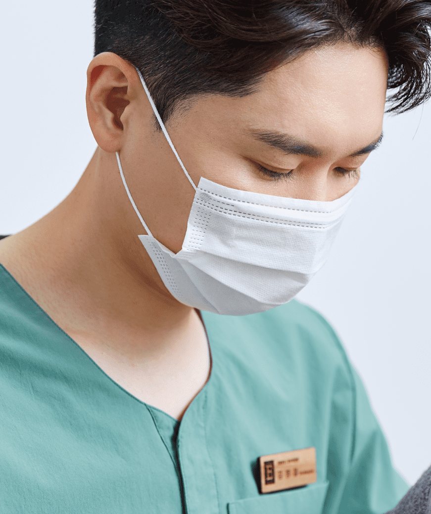 마스크를 쓰고 녹색 수술복을 입은 김병철 대표원장(진료 장면에서 원장만)